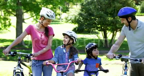 快乐的一家人一起骑自行车在公园里视频的预览图