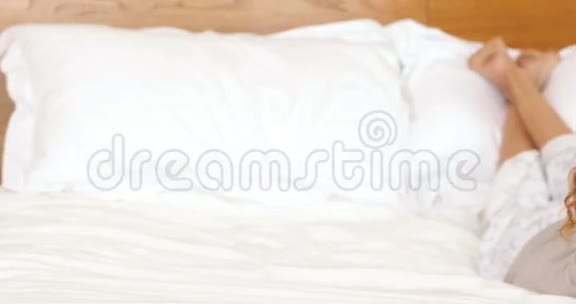 母亲和儿子躺在床上对着镜头微笑视频的预览图