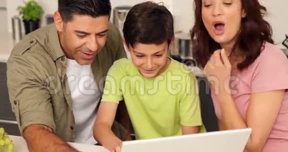父母和儿子一起用笔记本电脑视频的预览图