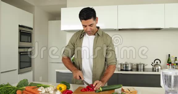 英俊的男人切蔬菜视频的预览图