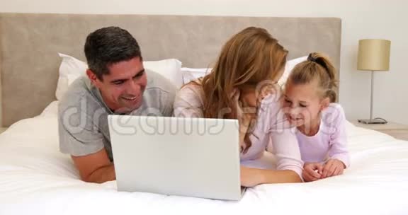 家人一起在床上用笔记本电脑视频的预览图