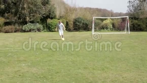 小男孩在花园里踢足球视频的预览图