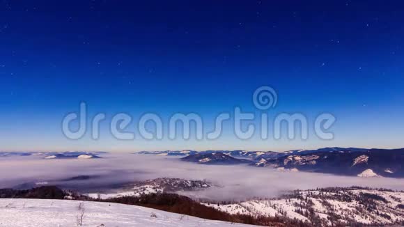 冬天雾以星状的天空在山上移动视频的预览图