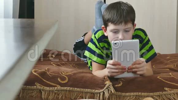 男孩在平板电脑游戏互联网上玩视频的预览图