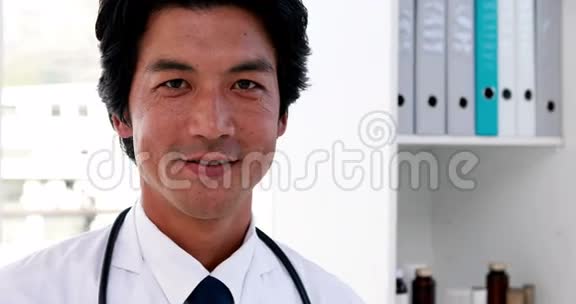 英俊的年轻医生对着镜头微笑视频的预览图