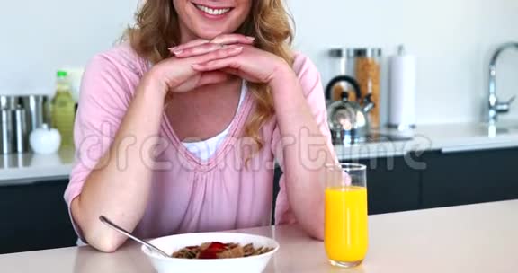 坐着吃健康早餐的漂亮女人视频的预览图