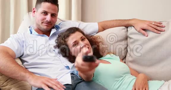 幸福的夫妻在沙发上看电视视频的预览图