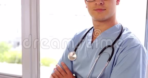 年轻的外科医生双臂交叉地微笑着视频的预览图