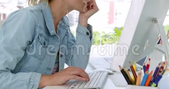 金发的年轻设计师在办公桌前工作视频的预览图