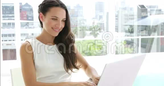 布鲁内特女商人在她的笔记本电脑上打字视频的预览图