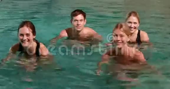 四个微笑的人在游泳池里做水上有氧运动视频的预览图