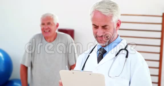 微笑的医生从剪贴板上阅读视频的预览图
