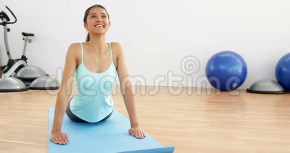 健身棕发在运动垫上做瑜伽视频的预览图