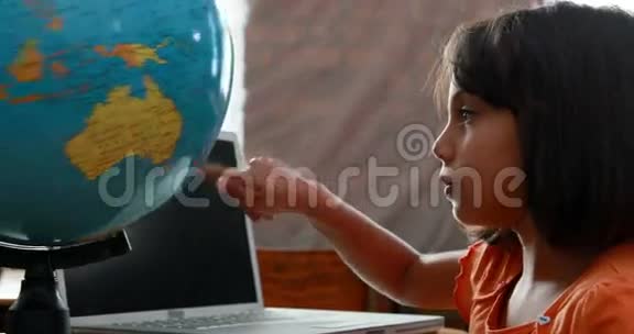在教室里看地球仪的小女孩视频的预览图