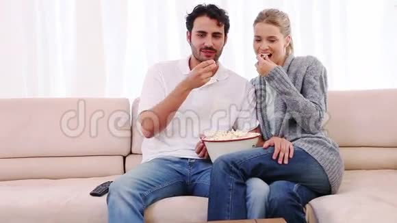 一对夫妇一边吃爆米花一边看电影视频的预览图