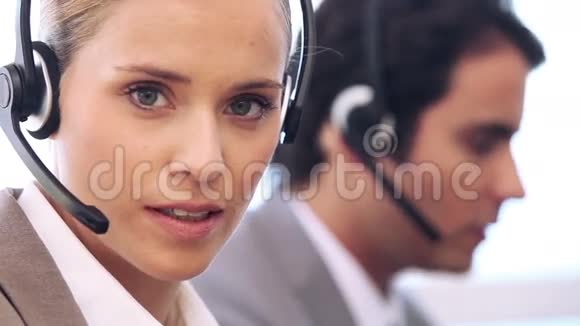 年轻的女商人用耳机说话视频的预览图