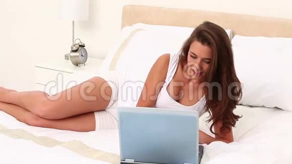 在使用笔记本电脑时撒谎的微笑女人视频的预览图