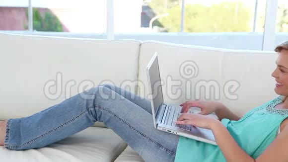快乐的金发女人用笔记本电脑视频的预览图
