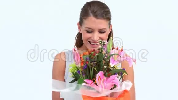 幸福的女人闻着美丽的花朵视频的预览图