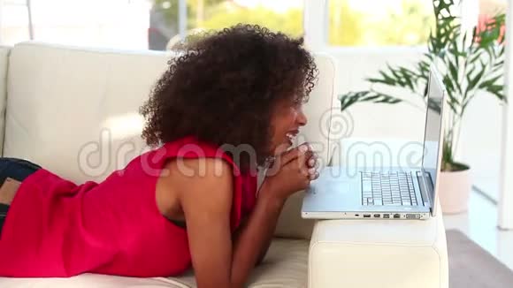 微笑的女人在她的笔记本电脑上写字视频的预览图
