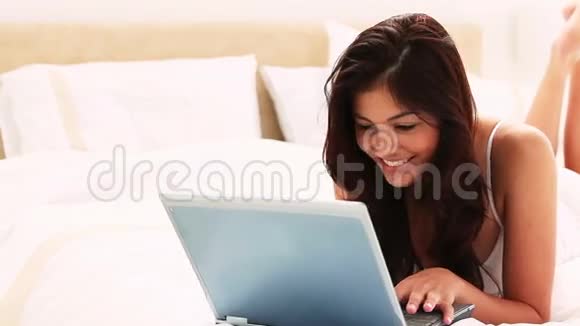 笑容满面的黑发在笔记本电脑上打字视频的预览图