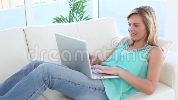 微笑的金发女人用笔记本电脑视频的预览图