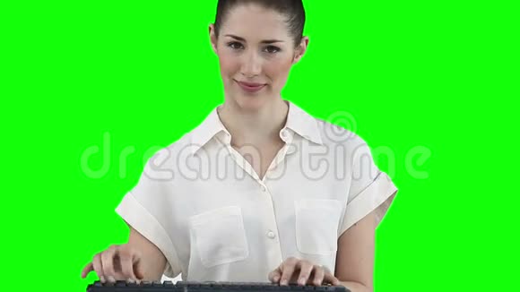 女人在键盘上打字时看着摄像机视频的预览图