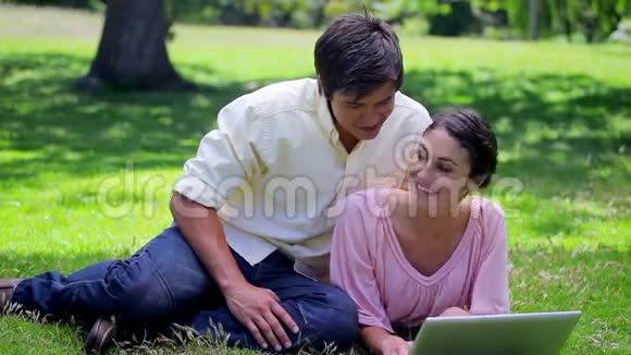 年轻夫妇看着他们的笔记本电脑视频的预览图