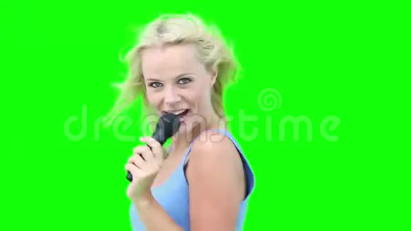 一个金发女人一边用麦克风唱歌一边跳舞视频的预览图