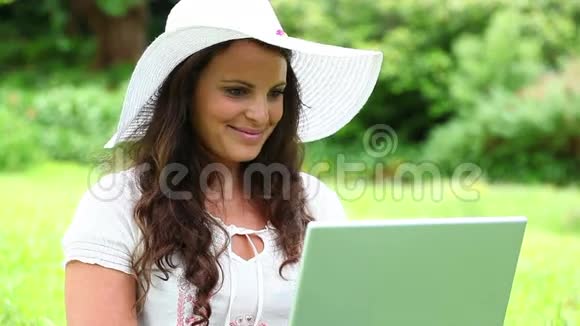 微笑的黑发女人用她的笔记本电脑视频的预览图