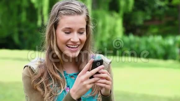 微笑的年轻女子打手机视频的预览图