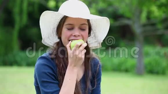 快乐的女人吃一个绿色的苹果视频的预览图