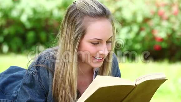 微笑的金发女人在看书视频的预览图