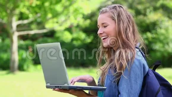 微笑的学生拿着笔记本电脑视频的预览图