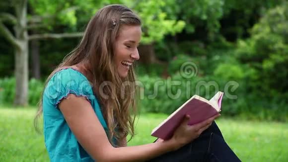 微笑着年轻的女人读小说视频的预览图