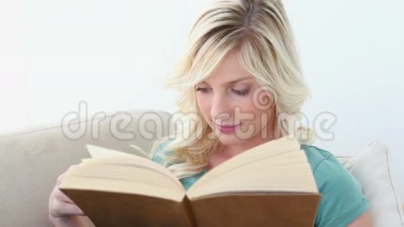 年轻的金发女人在看书视频的预览图