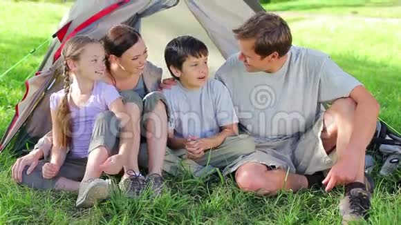 微笑的家人坐在草地上视频的预览图
