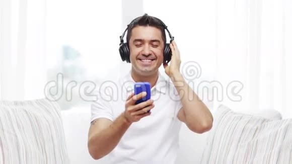 有智能手机和耳机的快乐男人视频的预览图