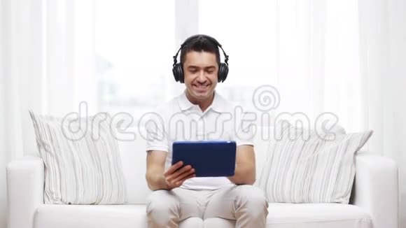 带着平板电脑和耳机的微笑男人视频的预览图