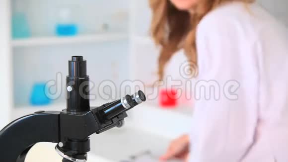 科学家女性通过显微镜观察视频的预览图