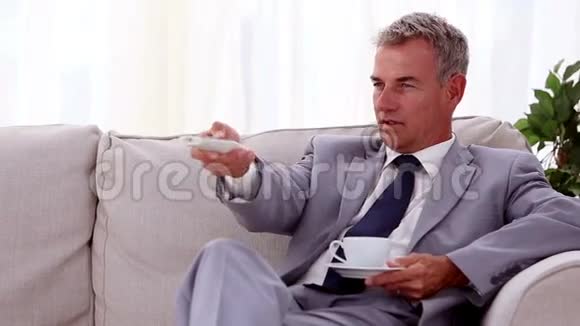 微笑的商人喝着一杯茶视频的预览图