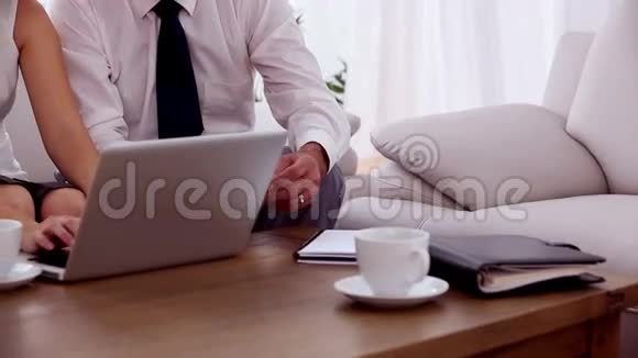 在沙发上用笔记本电脑工作的女商人视频的预览图