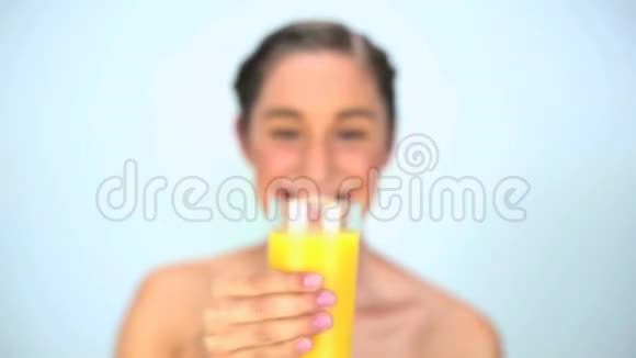 微笑着喝橙汁的年轻女人视频的预览图