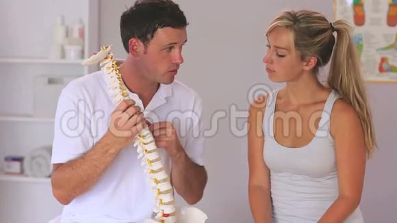物理治疗师向病人展示脊柱模型视频的预览图