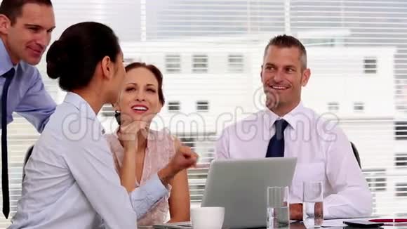 在办公室里一起工作的开朗的商人视频的预览图