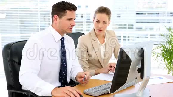 业务团队一起在办公桌上看电脑屏幕视频的预览图