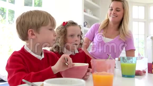 母亲和孩子们一起在厨房吃早餐视频的预览图