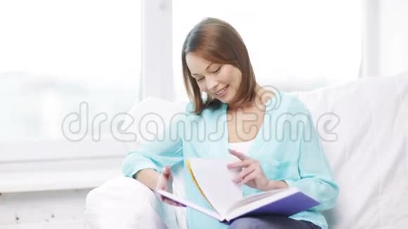 微笑的女人看书坐在沙发上视频的预览图