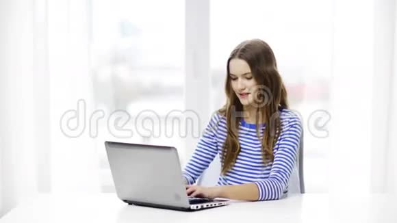 带着笔记本电脑在家微笑的少女视频的预览图