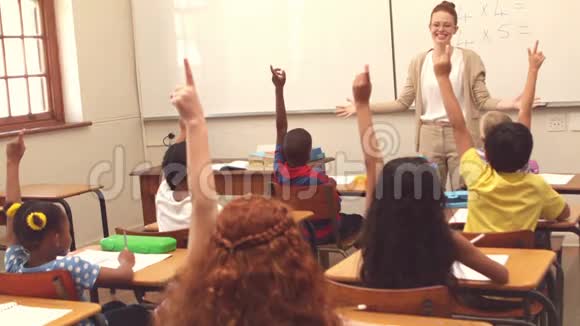 可爱的学生在教室里举手视频的预览图